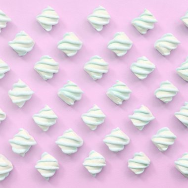 Renkli marshmallow pembe kağıt arka plan üzerine serilmiş