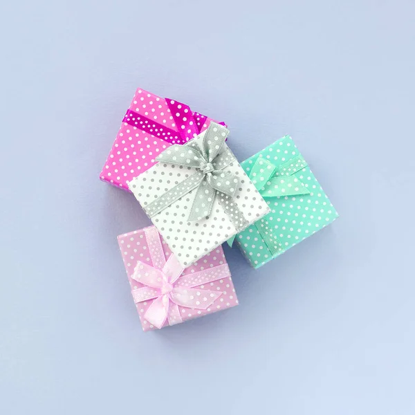 Σωρός από ένα μικρό χρωματιστό κουτιά δώρων με κορδέλες είναι σε ένα βιολετί φόντο — Φωτογραφία Αρχείου