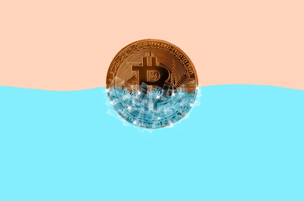 Bitcoin dorado congelado en bloques de hielo en agua azul — Foto de Stock