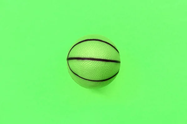 Mała Zielona piłka do koszykówki gra sportowa leży na tle tekstury — Zdjęcie stockowe
