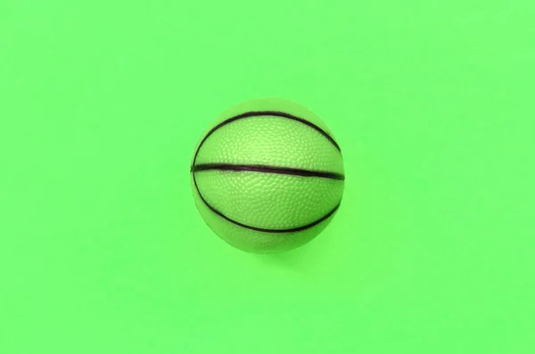 Piccola palla verde per il gioco di basket sport si trova su sfondo texture — Foto Stock