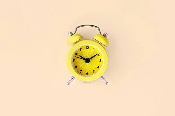 Rebanada de limón fresco en pequeño reloj despertador amarillo — Foto de Stock
