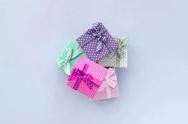 리본이 달린 작은 색의 선물 상자 더미가 보라색 배경에 놓여 있습니다. — 스톡 사진