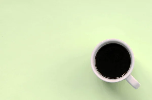 Piccola tazza di caffè bianco su sfondo texture di carta di colore calce pastello moda — Foto Stock