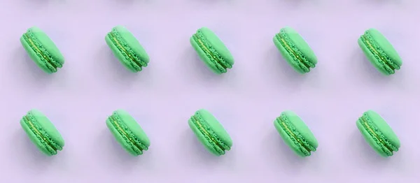 Green dessert cake macaron or macaroon on trendy pastel lilac background top view — Stock Photo, Image