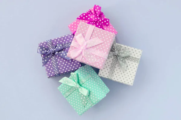 Stapel van een kleine gekleurde geschenkdozen met linten ligt op een violet achtergrond — Stockfoto