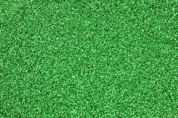 Una gran cantidad de lentejuelas decorativas verdes. Imagen de fondo con luces bokeh brillantes de pequeños elementos — Foto de Stock