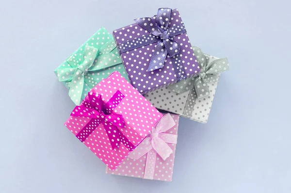 Il mucchio di piccole scatole regalo colorate con nastri si trova su uno sfondo viola — Foto Stock