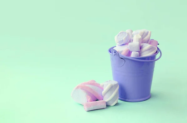 Egy miniatűr lila vödör töltött Marshmallow fekszik a zöld pasztell háttér — Stock Fotó