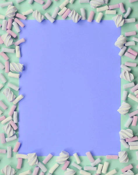 Guimauve colorée posée sur fond de papier vert et lilas — Photo