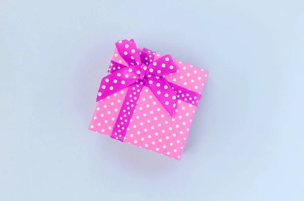 Kleine lila Geschenkschachtel mit Schleife liegt auf violettem Hintergrund — Stockfoto