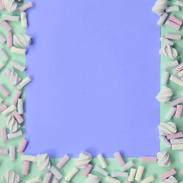 Guimauve colorée posée sur fond de papier vert et lilas — Photo