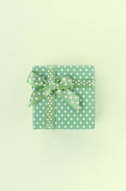 Kurdele li küçük yeşil hediye kutusu kireç arka plan üzerinde yatıyor