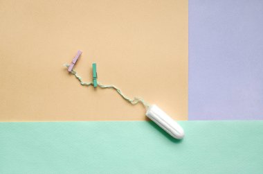 Tampon iki clothespins moda pastel menekşe, sarı ve mavi renklerin doku arka plan üzerinde yalan