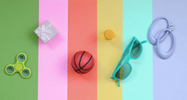 Küpe, güneş gözlüğü, içecek kutusu, basketbol topu, hediye kutusu ve spinner ile trendy moda pastel kompozisyon