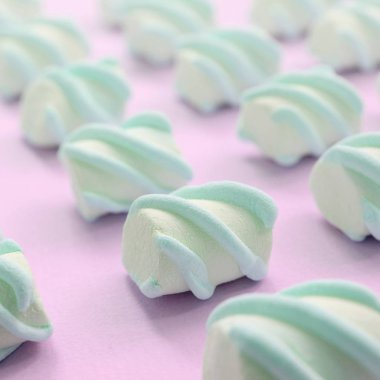 Renkli marshmallow pembe kağıt arka plan üzerine serilmiş