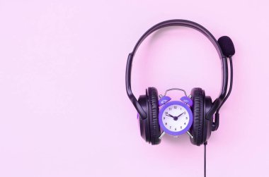 Müzik dinleme zamanı kavramı. Çalar saat ve kulaklıklar