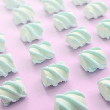 Renkli marshmallow pembe kağıt arka plan üzerine serilmiş