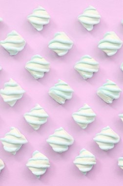 Renkli marshmallow pembe kağıt arka plan üzerine serilmiş