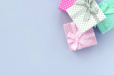 Kurdeleler ile küçük renkli hediye kutuları Yığını bir mor arka plan üzerinde yatıyor