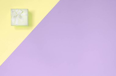 Küçük sarı hediye kutusu moda pastel sarı ve mor renklerin doku arka plan yalan