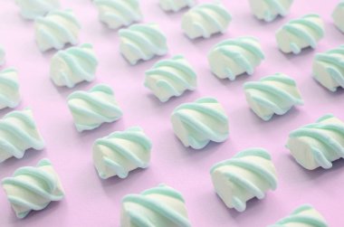 Renkli marshmallow pembe kağıt arka plan üzerine serilmiş