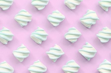 Renkli marshmallow pembe kağıt arka plan üzerine serilmiş
