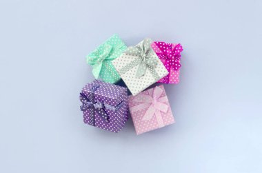 Kurdeleler ile küçük renkli hediye kutuları Yığını bir mor arka plan üzerinde yatıyor