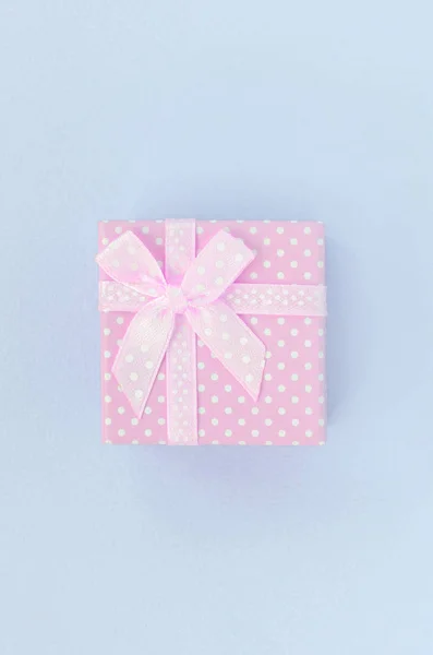 Kleine rosa Geschenkschachtel mit Schleife liegt auf violettem Hintergrund — Stockfoto