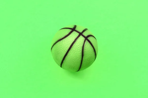 Kleiner grüner Ball für Basketball-Sportspiel liegt auf Textur Hintergrund — Stockfoto