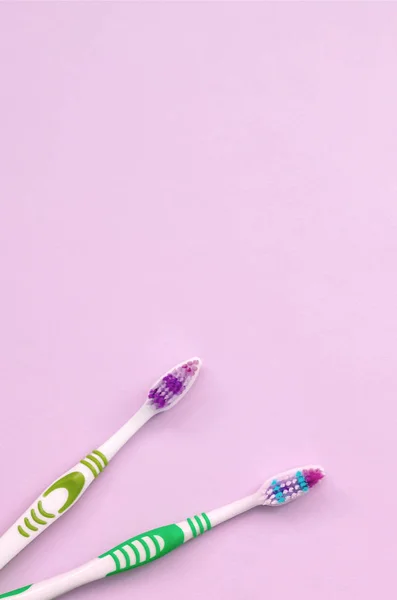 Dua sikat gigi berbaring di latar belakang pastel merah muda — Stok Foto