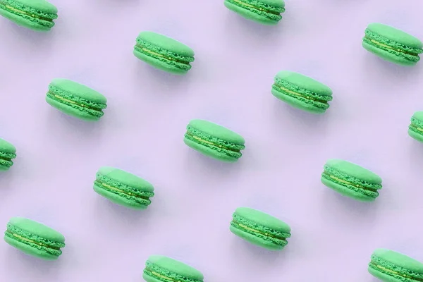 Зелений десертний торт макарон або макаруни на модному пастельному бузковому тлі вид зверху — стокове фото