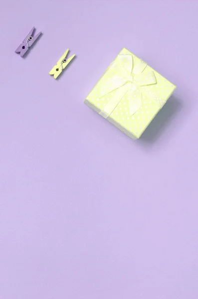 Небольшая розовая подарочная коробка и два колышка лежат на фактурном фоне — стоковое фото
