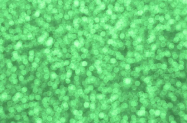 Sfocate paillettes decorative verdi. Immagine di sfondo con luci bokeh lucide da piccoli elementi — Foto Stock
