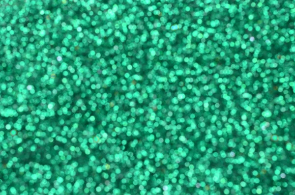 Bulanık yeşil dekoratif payetler. Küçük öğelerden parlak bokeh ışıkları ile arka plan görüntüsü — Stok fotoğraf