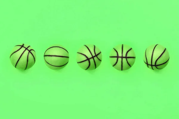 Veel kleine groene ballen voor basketbal sport spel ligt op textuur achtergrond — Stockfoto