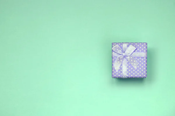 Kleine lila Geschenkschachtel liegen auf Textur Hintergrund der Mode pastellgrün Papier — Stockfoto