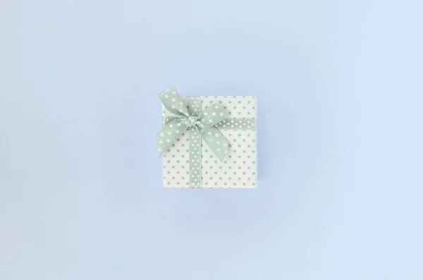 Small white gift box with ribbon lies on a violet background — Stock Photo, Image