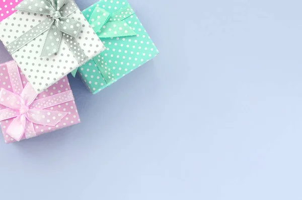 Montón de pequeñas cajas de regalo de colores con cintas se encuentra sobre un fondo violeta — Foto de Stock