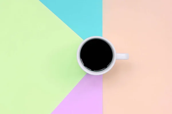 Pequeña taza de café blanco en el fondo de textura de la moda pastel rosa, azul, coral y papel de colores de cal —  Fotos de Stock