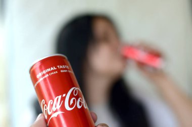 Esmer kadın içecekler Coca-Cola garaj iç ve erkek el içecek bir kola odak olabilir sunar