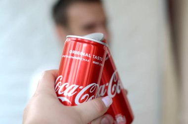 Mutlu genç adam garaj iç kadın arkadaşı ile Coca-Cola teneke olabilir yükseltmek
