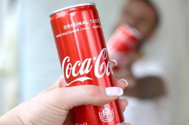 Mutlu genç adam garaj iç kadın arkadaşı ile Coca-Cola teneke olabilir yükseltmek