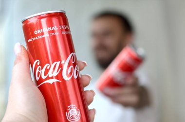 Mutlu genç adam garaj iç kadın arkadaşı ile Coca-Cola teneke olabilir yükseltmek