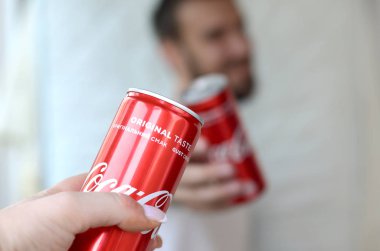 Mutlu genç adam garaj iç kadın arkadaşı ile Coca-Cola teneke olabilir yükseltmek