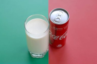 Coca Cola kırmızı teneke olabilir ve taze süt fincan kırmızı ve yeşil arka plan yüzeyi