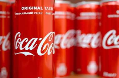 Coca-Cola logosu alüminyum kutulara baskılı ve alışveriş merkezi masasına yerleştirilir