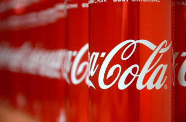 Coca-Cola logosu alüminyum kutulara baskılı ve alışveriş merkezi masasına yerleştirilir