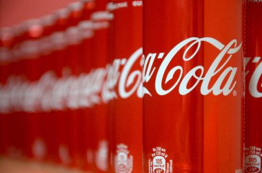 Coca-Cola logosu alüminyum kutulara baskılı ve alışveriş merkezi masasına yerleştirilir