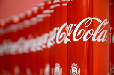 Coca-Cola logosu alüminyum kutulara baskılı ve alışveriş merkezi masasına yerleştirilir